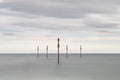 Stunning vibrant conceptual image of posts in sea standing senti