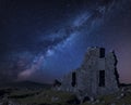 Stunning vibrant Milky Way composite image over abandoned Foggintor Quarry in Dartmoor with raking soft sunlight over ruins and