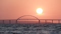 Stunning view of the beautiful sunset over the big river and the bridge, time lapse effect. Shot. Bright golden sun Royalty Free Stock Photo