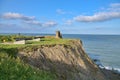 Stunning view of cliffy seascape  old black cannons  yellow flowers  and Black Castle ruins  South Quay  Corporation Lands Royalty Free Stock Photo