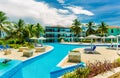 Stunning view of Colonial hotel grounds, beautiful inviting swimming pool and retro stylish buildings on dark deep blue sky