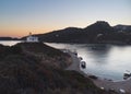 Stunning view of a dock at sunset with a small chapel on a hill over the water in Kythera Island Royalty Free Stock Photo