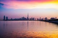 Stunning view of Dubai city skyline at sunset with a colorful sky and reflection on the water. Royalty Free Stock Photo