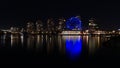 View of False Creek bay, Vancouver with Science World and illuminated buildings mirrored in the smooth water at night.