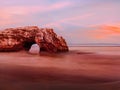 Natural rock arch on the Pacific Ocean beach in long exposure Royalty Free Stock Photo