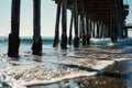 A stunning view of the ocean as seen from underneath a pier. Ideal for beach and nature-related projects Royalty Free Stock Photo