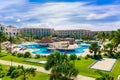 Stunning view of resort grounds, swimming pools with people relaxing and enjoying their vacation time