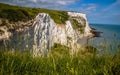 Stunning view of a rocky cliff edge along a grassy shoreline in White Cliffs of Dover, England Royalty Free Stock Photo