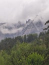 Stunning view of the rolling rocky hills shrouded in a mysterious mist, with an green forest