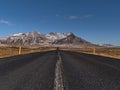 Stunning view of straight, empty road with diminishing perspective on SnÃÂ¦fellsnes, Iceland with rugged, snowy mountains. Royalty Free Stock Photo