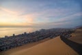 Stunning view to sand dunes, ocean and Iquique city at sunset