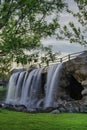 Stunning view of the wide foamy waterfall running down from a small cliff in the park