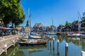 Stunning views over historic dutch yacht harbour with classic dutch historical houses and bike riders