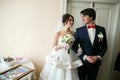 Stunning wedding couple stands in the room looking at each other