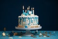 A stunning white birthday cake featuring teal ganache, star decorations