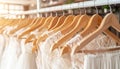 Stunning white bridal gowns elegantly showcased on hangers in a boutique bridal salon