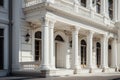 A stunning white building featuring elegant columns and numerous windows, standing tall and inviting in its grandeur, Neoclassical Royalty Free Stock Photo