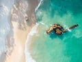 Stunning wide angle aerial drone view of a rock in the water at Otama Beach near Matarangi on the Coromandel Peninsula in New Zeal