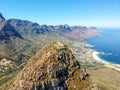 Stunning wide angle aerial drone view of the summit of Lion`s Head mountain and the suburb of Camps Bay with the Twelve Apostles m Royalty Free Stock Photo