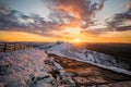 Stunning winter snowcapped mountain range hills summit sunrise. Mam Tor Derbyshire Peak District hill ridges hiking in winter snow