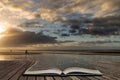 Stunning Winter sunrise over West Wittering beach in Sussex England with wind blowing sand across the beach in pages of open book