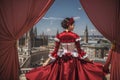 Stunning woman a beautiful red dress in an empty old town square, view from the back, generative AI illustration