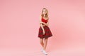 Stunning young blonde woman girl in red sexy clothes posing isolated on pastel pink wall background studio portrait Royalty Free Stock Photo