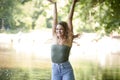 Stunning young brunette woman standing in shallow creek