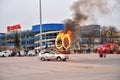 Stunt man jumps into burning rings of a moving car during the show Lada-truck Rodeo thing in St. Petersburg