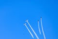 Stunt planes with their white contrails against a blue sky Royalty Free Stock Photo