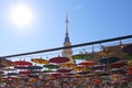 Stupa in Thialand temple decorative with  open umbrella hanging and the sun on bright blue sky background Royalty Free Stock Photo