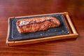 A stupendous piece of picaÃÂ±a roasted over charcoal with a good handful of salt flakes on a metal and bamboo tray Royalty Free Stock Photo