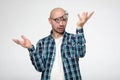 Stupid looking bald man with a grimace on face, wearing slanting glasses and making a strange gesture with hands.
