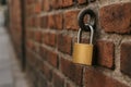 Lock hangs on a weathered brick wall in an urban setting at dusk Royalty Free Stock Photo