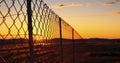 The Sturdy Mesh and Barbed Wire Fence Enclosing an Area, Captured at Dusk Royalty Free Stock Photo