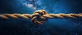 Sturdy rope with knot against a backdrop of starry night sky. Concept of teamwork, unity, cooperation, partnership, and support Royalty Free Stock Photo