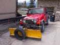 A sturdy vehicle equipped for serious snow removal parked outside a house in alaska