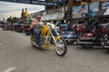 A byker riding his chopper motorcycle during the annual Sturgis Motorcycle rally in the main street of the city of Sturgis Royalty Free Stock Photo