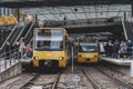 People waiting for two trains to stop at the station Royalty Free Stock Photo