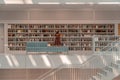 Stuttgart, Germany - Aug 1, 2020 - Woman with mask reading book at Stadtbibliothek library with sun light in the morning