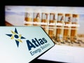 Cellphone with logo of oil and gas company Atlas Energy Solutions Inc. on screen in front of website.