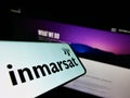 Cellphone with logo of satellite company Inmarsat Global Limited on screen in front of business website. Royalty Free Stock Photo