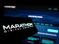 Mobile phone with logo of American company Marathon Digital Holdings Inc. on screen in front of business website.