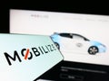 Mobile phone with logo of automotive mobility company Mobilize on screen in front of business website.