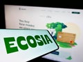 Mobile phone with logo of German search engine company Ecosia GmbH on screen in front of business website.