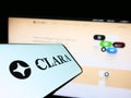 Mobile phone with logo of Mexican fintech company Clara on screen in front of business website.