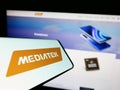 Mobile phone with logo of Taiwanese semiconductor company MediaTek Inc. on screen in front of website.