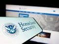 Mobile phone with seal of American Department of Homeland Security (DHS) on screen in front of website. Royalty Free Stock Photo