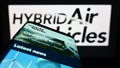 Mobile phone with webpage of company Hybrid Air Vehicles Limited (HAV) on screen in front of business logo.