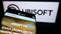 Mobile phone with webpage of French video game company Ubisoft Entertainment SA on screen in front of logo. Royalty Free Stock Photo